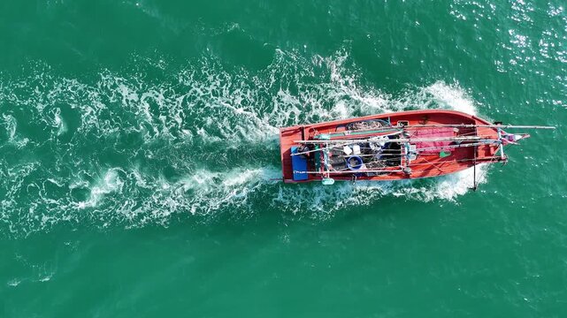 Fishing boat go to ocean for catching fish all a long night - at Thailand. Top view of Fishing Boat running verry fast on the sea to port.