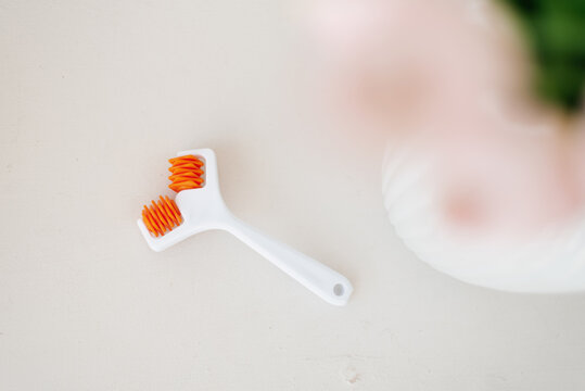 Orange Facial Massage Roller On Neutral Table