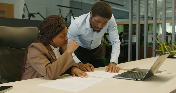 Team members work together sharing both online and printed materials