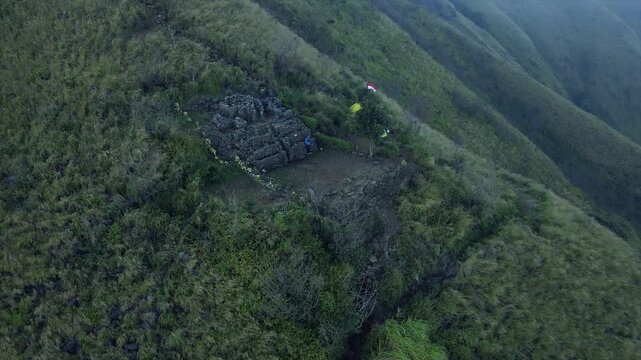4K Aerial View of Ancient Stone Temple Ruins on the Lush Green Slopes of Mount Penanggungan in Indonesia.