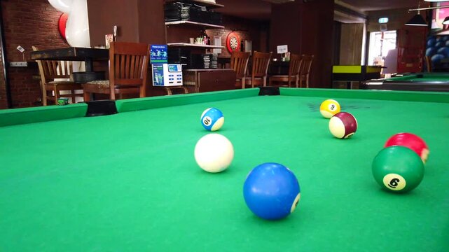 Close-up footage of a pool shot with billiard balls as the white ball pots the red ball. The clip captures the moment of a billiards game, making it ideal for sports content, bar games scenes