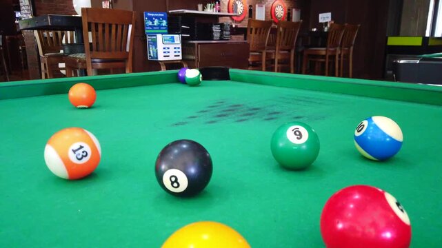 Close-up footage of two pool shots with a billiard ball being potting then scattering the balls across the table. the moment of a billiards game, making it ideal for sports content, bar games scenes
