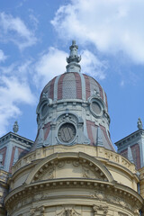 Naklejka premium The elaborate neo baroque dome of a historic building in Zagreb features decorative oval windows and intricate stone carvings against a blue sky