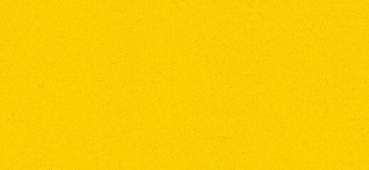Obraz premium Bright yellow background with paper texture and visible grain, abstract surface for modern design and advertising.