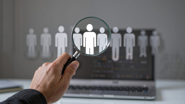 Magnifying glass over a person icon on a laptop