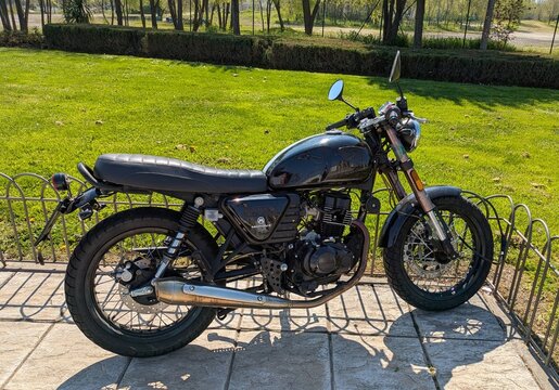 Vista lateral de moto Hanway Raw 125 Caf&eacute; Racer  estacionada en Madrid, Espa&ntilde;a, 22 de marzo de 2026	