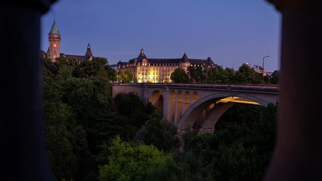 Timelapse clip of the Adolphe Bridge in Luxembourg City with the old historical buildings behind. The bridge was finished in 1903 and named after the Grand Duke Adolphe. Seen in the late blue hour
