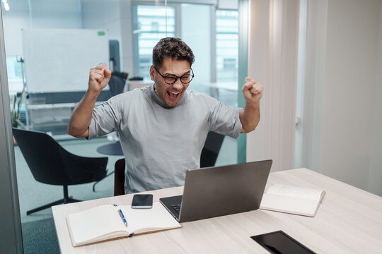 Individual Expresses Triumph Through Energetic Gesture And Joyful Surroundings After Milestone Success