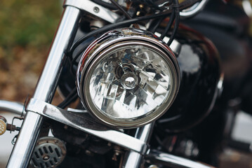 Fototapeta premium black motorcycle front headlight closeup view, safety on road, riding motorcycle concept