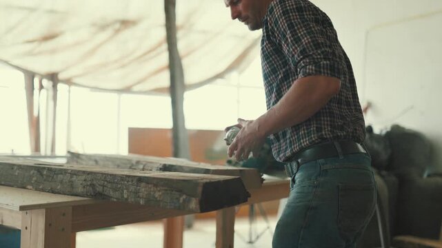 Carpenter measuring a wooden plank in his workshop