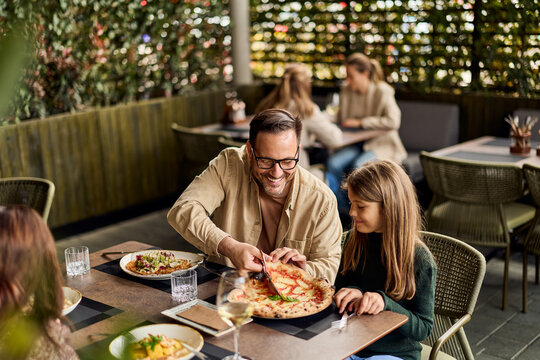 Father Sharing Pizza With Daughter At Outdoor Restaurant - Family Dining, Smiling Moments