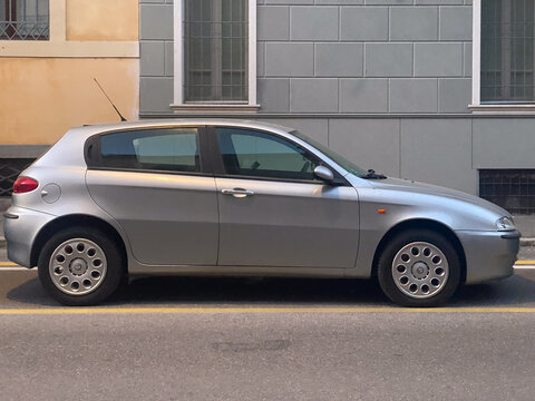 Alfa Romeo 147 5 door hatchback parked on a city street, silver Italian car model 2000s era