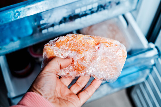 a man takes frozen chicken from the freezer