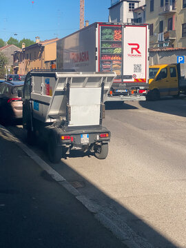 Piaggio Porter operating as micro garbage truck on city street alongside Romagna fresh produce delivery logistics