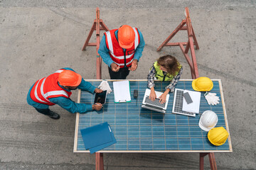 Naklejka premium Construction worker solar panel team helmet laptop table safety planning inspection
