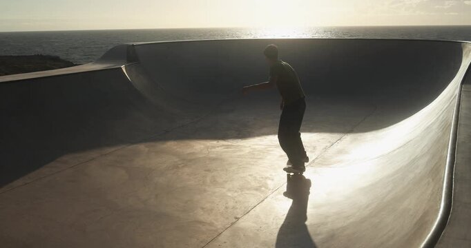 Skater boys having fun at skateboard park outdoor during sunset time - Summer lifestyle, young people and extreme sport concept 