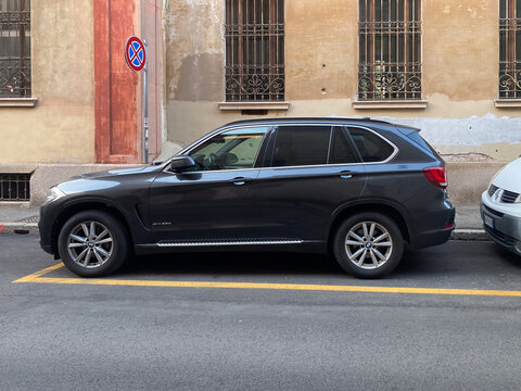 BMW X5 SUV parked on city street with building background, urban environment, transportation