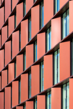 Orange building exterior detail with modern architecture facade windows and abstract pattern geometry grid texture in bold contemporary design