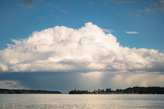 Storm rolling across lake with dark rain clouds above marina