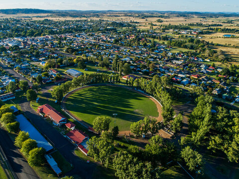 Buildings around Glen Innes Showground ring in bright sunlight from aerial view