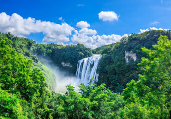 Panoramic view of Huangguoshu Waterfall surrounded by lush green forest in Anshun, Guizhou, China © ABCDstock