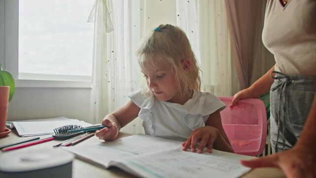 Preschool homework session with parental support at home. Preparing for school by developing early literacy and discipline