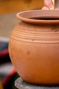 A close up of a handmade clay pot with decorative patterns The Art of Craftsmanship