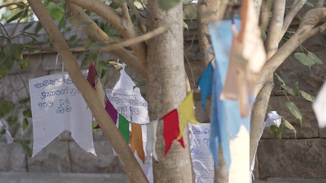 Close-up of a string of Buddhist prayer flags hanging on a line, highlighting colorful symbols of faith and spirituality.