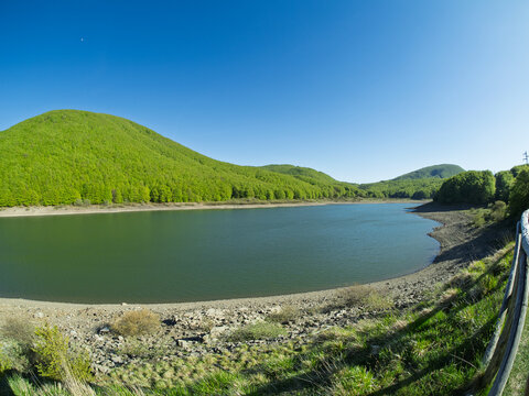 Italian mountain pass with lake and autumn foliage forest, 