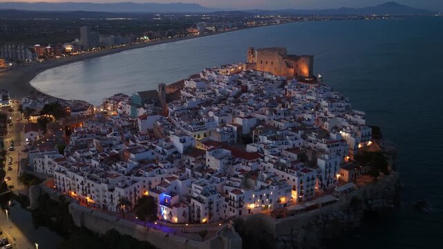 Night aerial view of Peniscola old town and castle with night illumination, drone shot of a popular coastal town on Costa del Azahar, Valencia, Spain. Vacation in Spain, Peniscola drone view