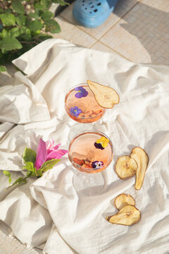 Rose wine glasses on tropical background. Summer cocktails