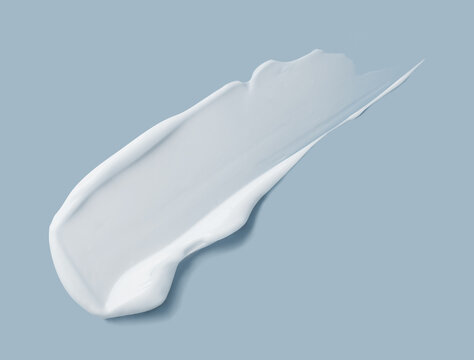 White cosmetic cream smear texture on blue
