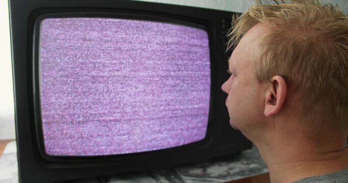 Person hypnotized by static noise on CRT television screen. Television hypnosis and analog media influence concept