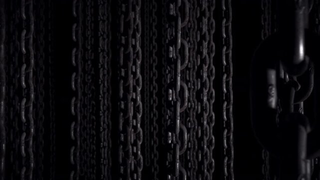 Walking through a dark space with chains hanging from the ceiling.