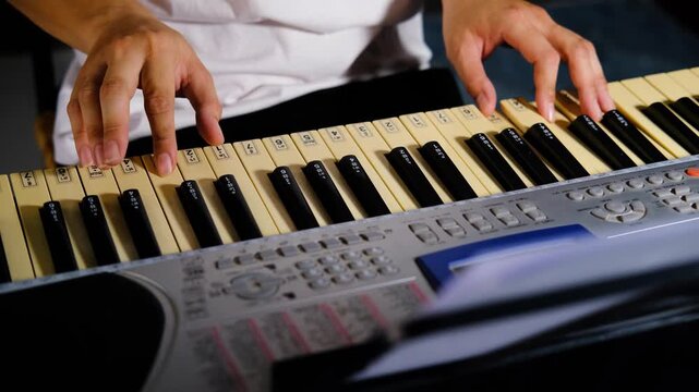 Close-up hands Learning to play basic piano keyboard. Practice synthesizer at home.