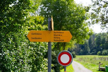 Close-up of yellow direction signs at hiking trail at Swiss village of Glattfelden on a sunny late summer day. Photo taken September 7th, 2025, Zurich Glattfelden, Switzerland. © Michael Derrer Fuchs