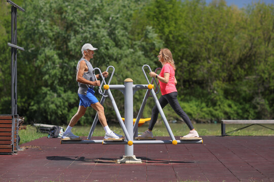 Mature couple exercising on outdoor air walker gym equipment