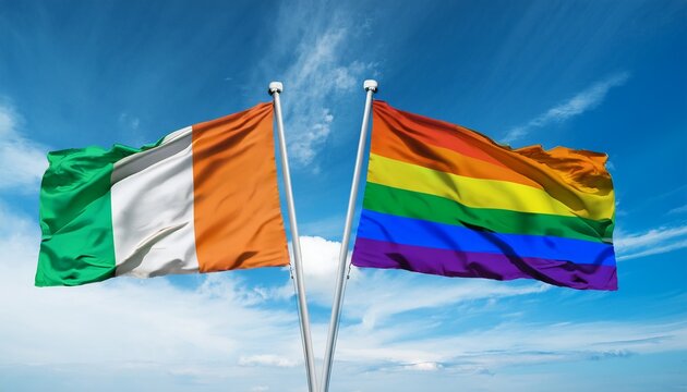 ireland flag and pride flag waving on blue sky background