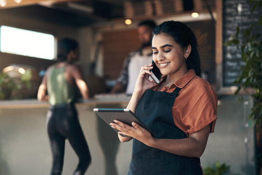 Waitress, tablet and phone call with woman in restaurant for small business, menu planning and startup. Tech, cafe shift roster and hospitality with happy person at coffee shop for catering app