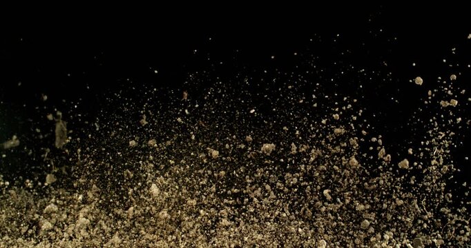 Super Slow Motion of Flying Dirt Soil in the Air. Filmed on High Speed Cinema Camera , 1000fps. Isolated on Black Background.
