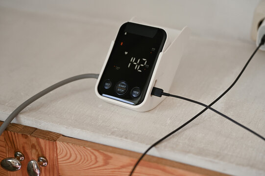 Close up of woman measuring her blood pressure with digital blood pressure monitor