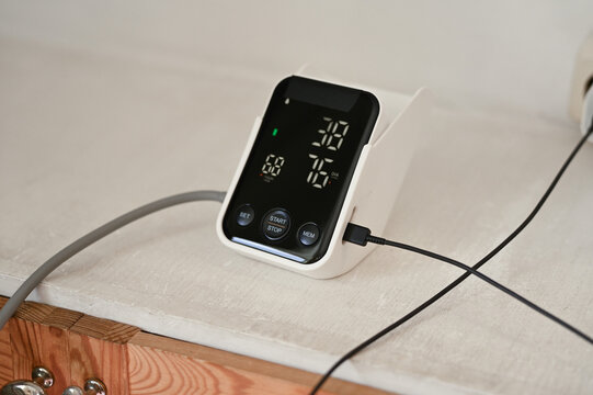 Close up of woman measuring her blood pressure with digital blood pressure monitor