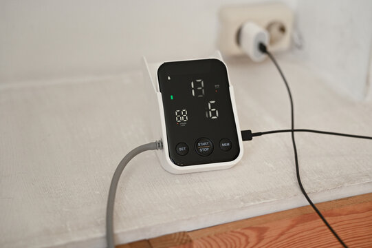 Close up of woman measuring her blood pressure with digital blood pressure monitor