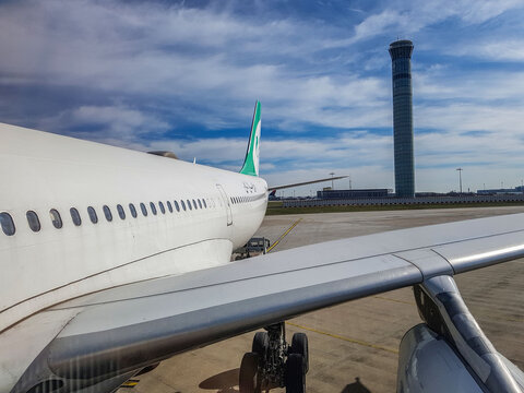 Paris, France - March 11, 2017 - airbus a340 at park position and behind this plane air traffic control tower of paris charles de gaulle airport ATC 