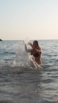 Woman beach splash enjoying a sunny day while swimming and playing in the ocean waves during a summer vacation