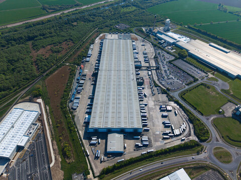 Massive logistics distribution centre with HGV trucks lined up in loading bays, aerial view, Goole, UK.