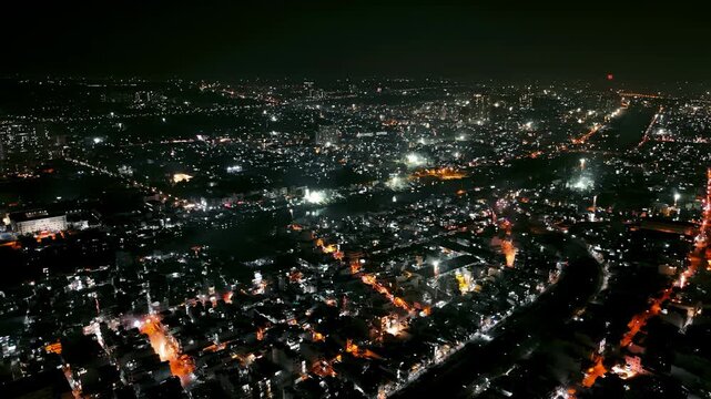 A dynamic aerial drone view of widespread fireworks shooting everywhere across a bustling Asian metropolis at night, celebrating New Year's Eve. Features a dense urban skyline and river