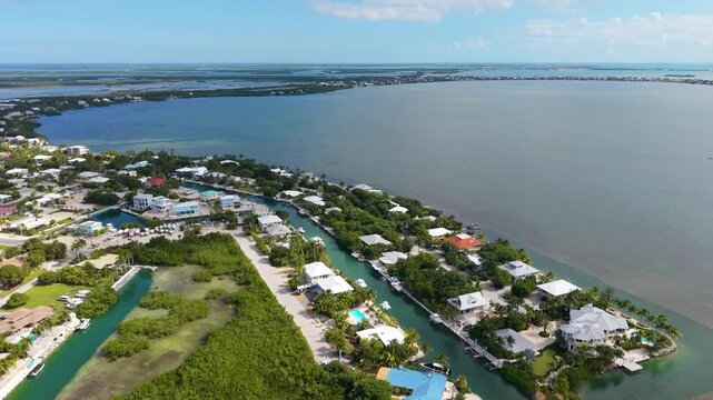 Cinematic drone perspective of the exclusive Coco Plum Beach residential area in Marathon, featuring luxury canal-front homes and private docks.