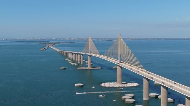 High-altitude drone perspective showcasing the massive scale and yellow pylon engineering of the Sunshine Skyway Bridge.