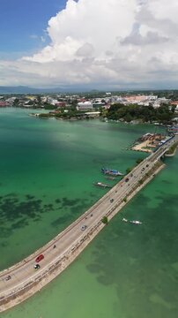 Vertical drone ascends over Va&ntilde;o Bridge and Borja Bridge, revealing Panglao&rsquo;s turquoise shoreline and townscape
